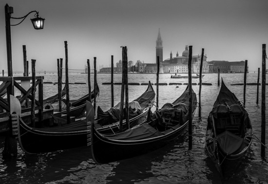 Venice, Italy. Popular view with Venetian gondolas in foreground and San Giorgio Maggiore island in the background at an overcast rainy day.