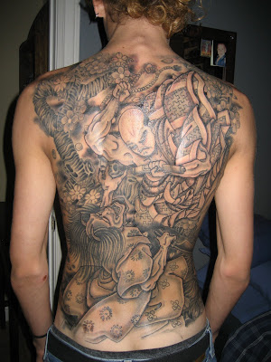 Traditional Japanese tattoo covers arms, shoulders, and the back.