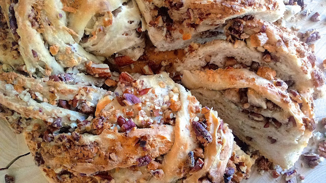 Gorgonzola & Toasted Pecan Sourdough Wreath on a cutting board with a few slices exposed