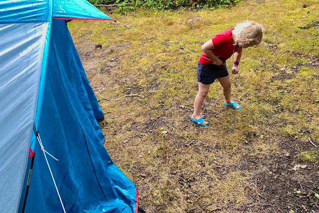 a child pulling on a guide rope of a tent
