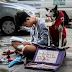 A young man patiently doing his homework  under the LRT while his bestfriend dog busy approaching people for donations