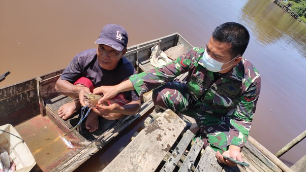 Kopda Samsuri Anggota Satgas TMMD Ke-111 Kodim 1207/Pontianak Bantu Warga Angkat Bubu Penangkap Ikan Tradisional