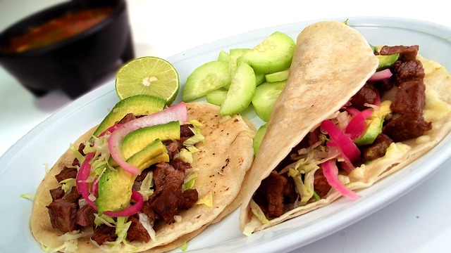 Two Tacos with Shredded beef, lettuce, tomato, and avocado