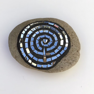Mosaic mirror on Stone. A spiral of mirror with a Hematite heart at the center.  By artist Sue Betanzos.com
