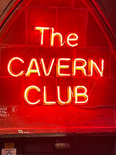 An orange neon sign that says, 'The Cavern Club.'