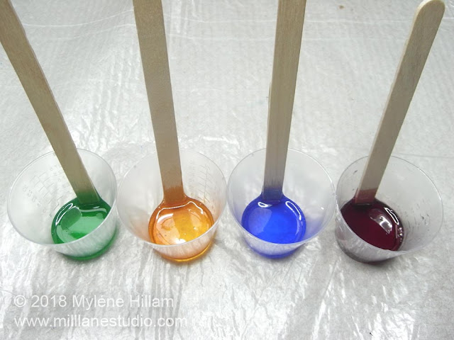 Cups of resin coloured green, amber, blue and red