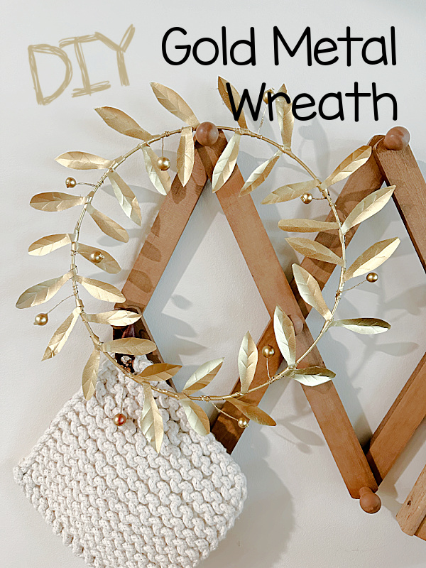 gold metal wreath on hooks with overlay pin