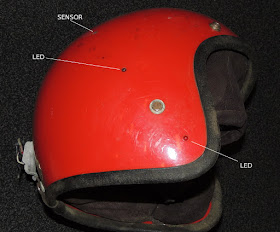 The side view of a helmet with two LEDs and a light sensor labeled.