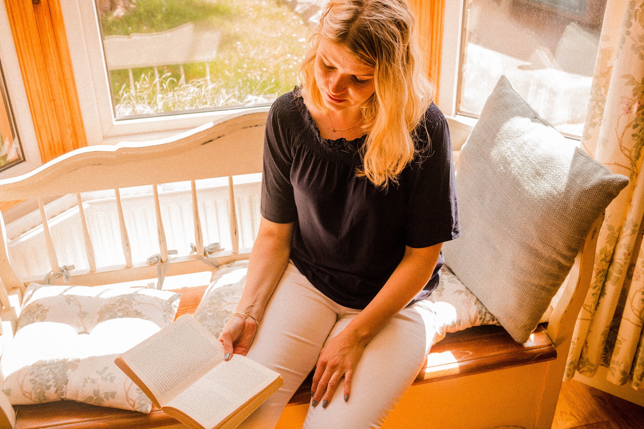 Book Blogger Chloe Harriets Reading Book in Window