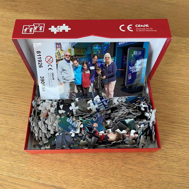 an open box sitting on a table, with lots of jigsaw pieces in it