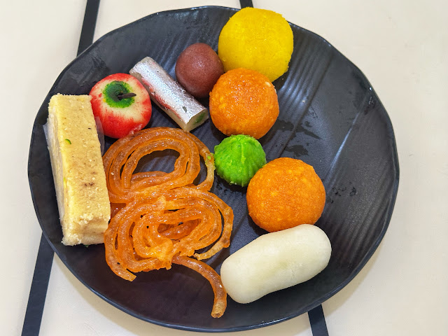 a plate of various Indian sweets in Bangkok, Thailand