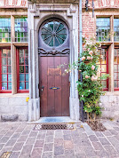 Ghent in one day: Wood door with flowers and a round window