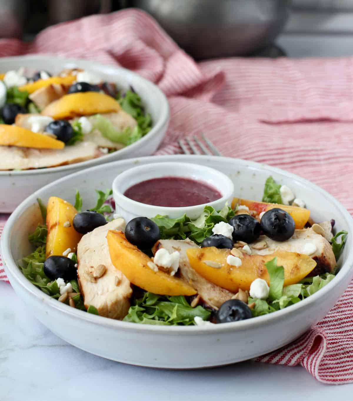 Grilled Chicken and Peach Mixed Green Salad in bowls.