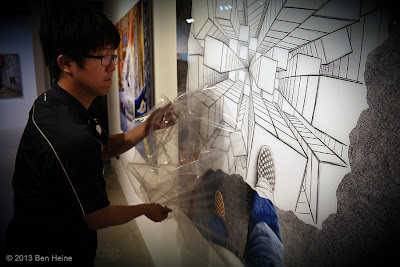 Ben Heine Art Exhibition : Removing the protective film from the signed acrylic Lamina Pencil Vs Camera prints