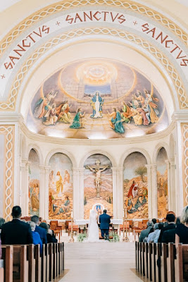 bride and groom kneeling at cathedral during ceremony