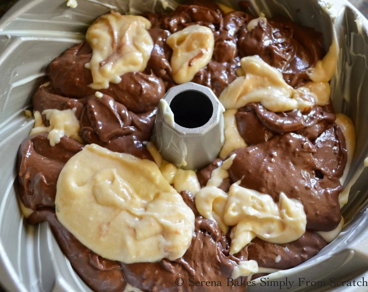 Layers of chocolate and buttermilk cake batter in a swirl bundt pan.