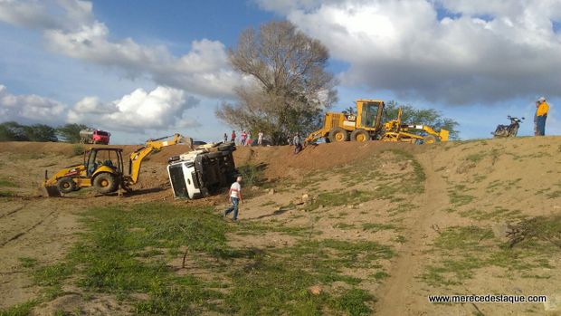 Caminhão caçamba tomba durante serviço em parede de açude