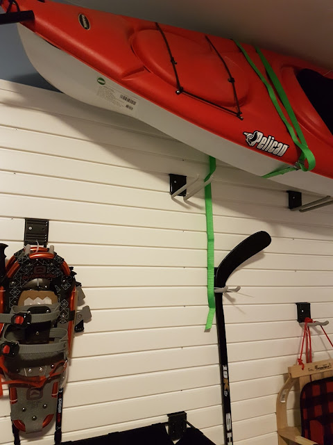 kayaks and snowshoes  stored on a garage wall