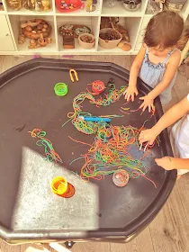 rainbow spaghetti and tweezers on a tuff tray