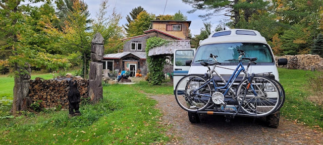 Camper van parked in driveway with house in background.