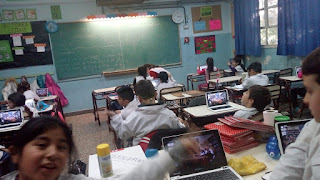 La imagen muestra a los alumnos en la escuela 16 siguiendo las alternativas de la transmisión en vivo 