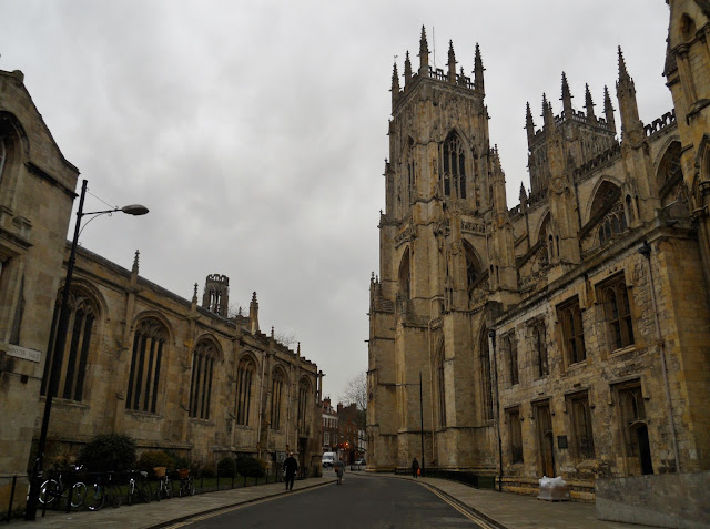 York, England. St. Nicholas Cathedral,  History, Architecture,  Streets, Wall, Walk, York is a small walled city situated at the middle of the busy railway route from Edinburgh to London. The city itself is very small and can be covered on foot twice in a day. That is what we did when we got there. Here are some pictures of the streets of York. Hartleys - the Best Sandwich Shop in York (As written on a board outside the shop). No doubt, it is the cutest though.Some dilapidated old ruins near the Museum Gardens. A lot of Ghost walks are organized here. The street leading towards the York Minster. See how empty they are. The entire population of York in 2007 was less than 2 Lakh people.Beautiful building enroute to the York Minster. On closer inspection, it turned out to be Grays Solicitors. Not too exciting.St. Wilfrid's Church opposite Gray's Solicitors. The construction of the Church was completed in 1864 costing around £10,000 - a little less than the tution fees for my MA.The York Minster Cathedral. It took us a while to locate the main entrance of this huge building. St. Michael le Belfrey Church besides the York Minster. A lot of these buidlings have been standing since the medieval times. The sign for the Ye Olde Starre Inn across stonegate -  the inn has been standing since the English Civil Wars in the mid-17th Century. The building itself (not in this picture) was once used as a hospital and mortuary. No wonder several ghosts haunt the premises. Trade Secret Salon near Coppergate. This was close to the Jorvik Viking Centre. West Cornwall Pasty Co. at the Coppergate Shopping Centre. Food abounds at every corner in York. Never make the mistake of eating too much on an outing. You will end up feeling wretched.York at night with brilliant moon high up in the sky. Well, it will not be fair to call it night though since it was barely 4:30 in the evening.The York city wall - ﻿more miles of this wall are intact as compared to the other cities in England.