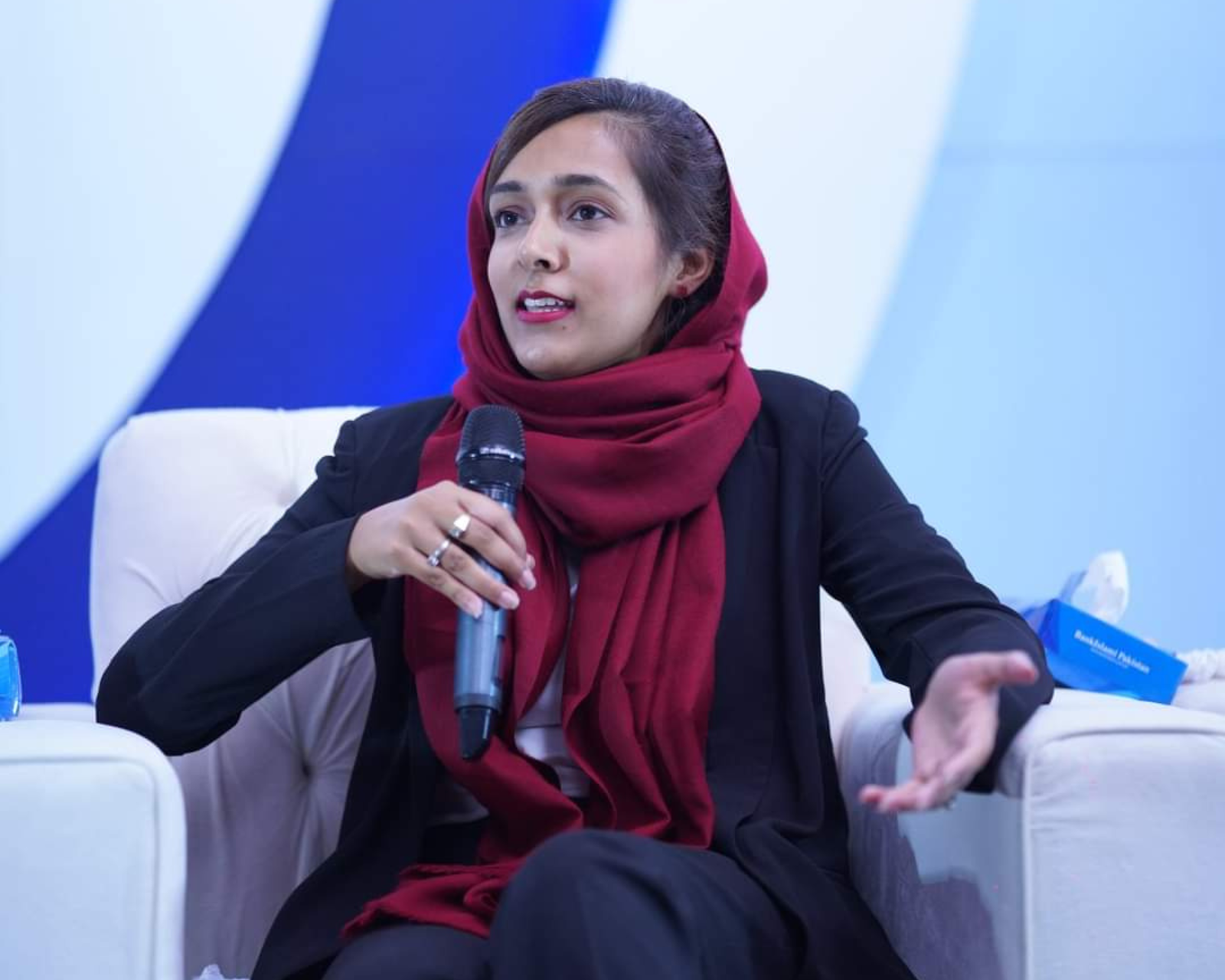 Photo of Aqsa Kausar holding a microphone