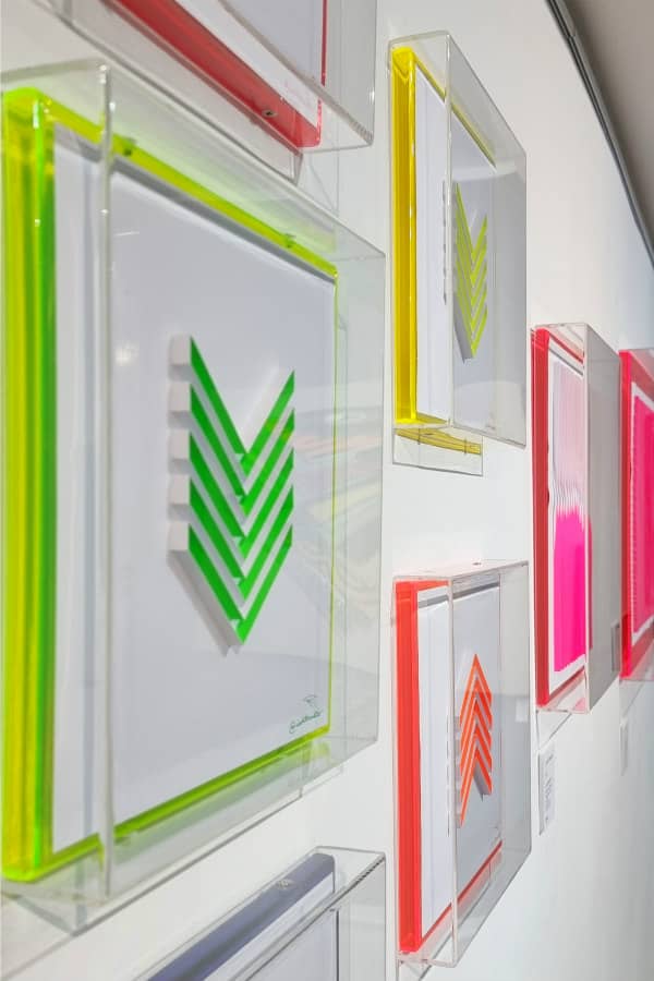 wall display of geometric fluorescent paper art with framed border