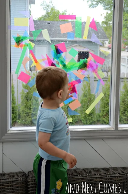 Toddler standing next to some abstract window art