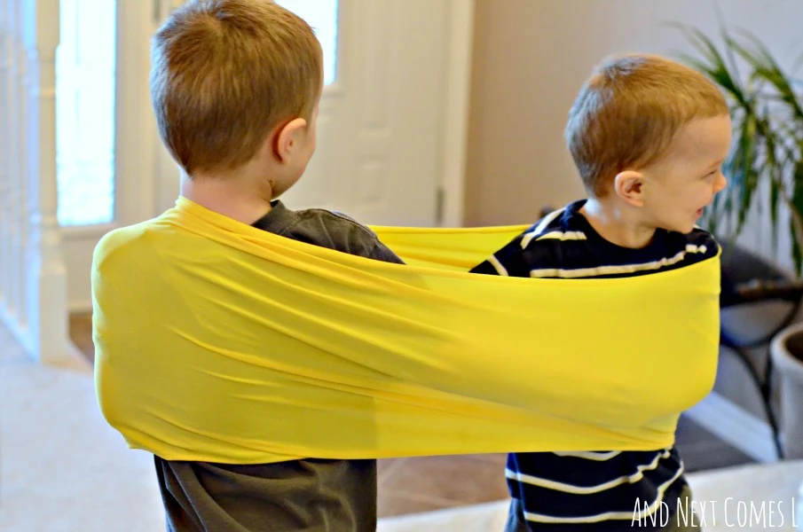 Using homemade stretchy resistance bands with more than one child to stimulate proprioceptive sensory input from And Next Comes L