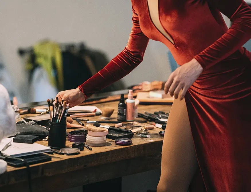 mujer-en-vestido-rojo-tomando-pindel-de-maquillaje