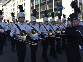 Pic of American marching band in smart white and black uniforms carrying their instruments