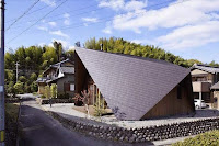 Origami House Design with A-Frame in an Old Village Surrounded by Mountains