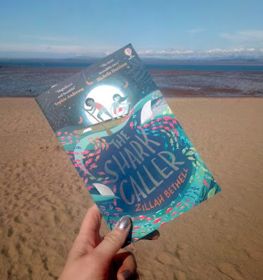 The Shark Caller by Zillah Bethell held up at Morecambe Bay Beach