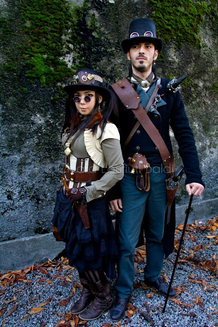 Couple wearing steampunk costumes. Top hat, goggles, cane, gun, etc. Men and women's steampunk cosplay and fashion