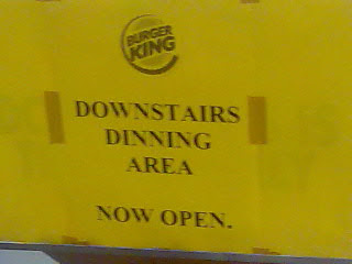 A Burger King sign reading Downstairs Dinning Area Now Open