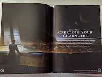 A chapter splash page, covering two facing pages. An illustration of a man standing on a balcony overlooking a city at night with two moons visible above the horizon. On the left page, some text introducing the chapter is overlaid on the illustration.