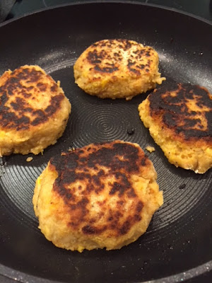 4 cooked chickpea burgers in a pan