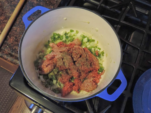 The ground beef being added to the pot. 