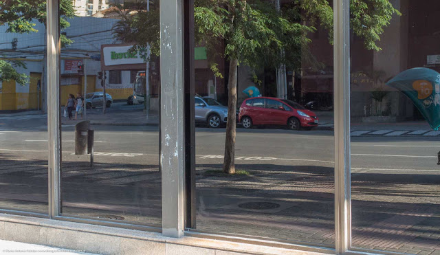 Rua refletida no vidro de um edifício