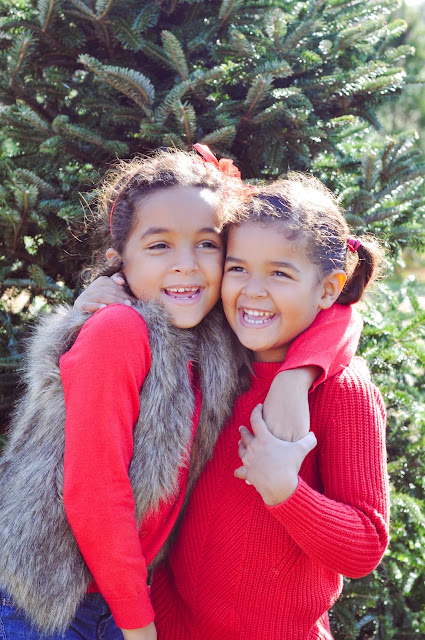 Sisters hugging at a Christmas Tree Farm