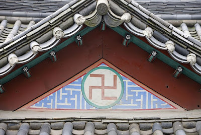 Red swastika surrounded by blue swastika pattern, below the roof of Bongeunsa temple, South Korea.