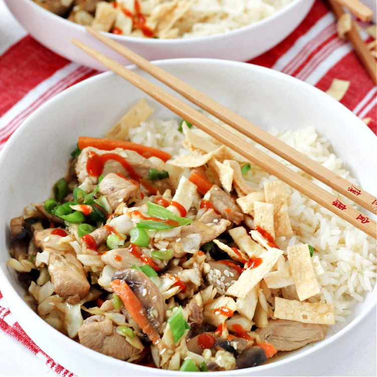 Two quick and easy pork and cabbage stir fry bowls with chop sticks ready to eat