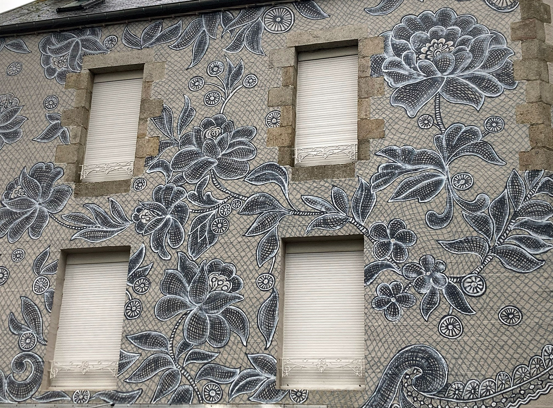 Delicados encajes pintados transforma la fachada de un edificio en Francia