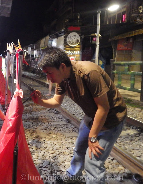 writing wishes on a folded skylantern at the railroad tracks of Shifen Old Street