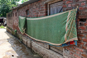 sari being hung out to dry on a village wall