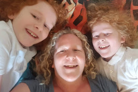 Top tips for better sleep selfie showing mum and two sons lying grinning on a child's bed