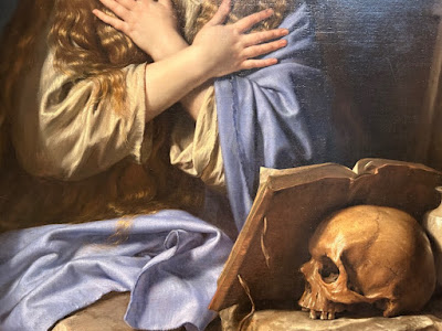 Mary Magdalene close up of hands cross over the chest with book and skull in view