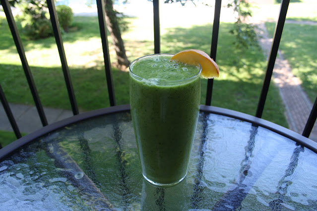 Verre de smoothie vert garni d'une tranche de pêche