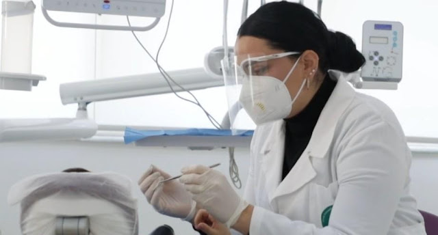 Un dentista cura un bambino a Tirana